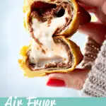 A close up of someone holding an air fried Creme Egg croissant cut in half. A text overlay says 'Air fryer Creme Egg croissant'