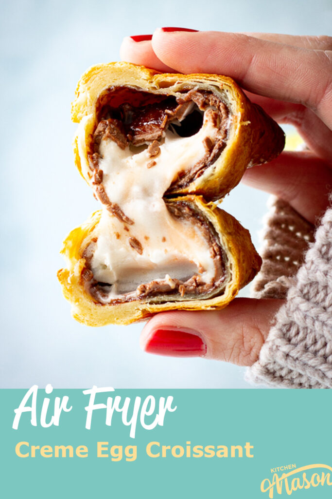 A close up of someone holding an air fried Creme Egg croissant cut in half. A text overlay says 'Air fryer Creme Egg croissant'