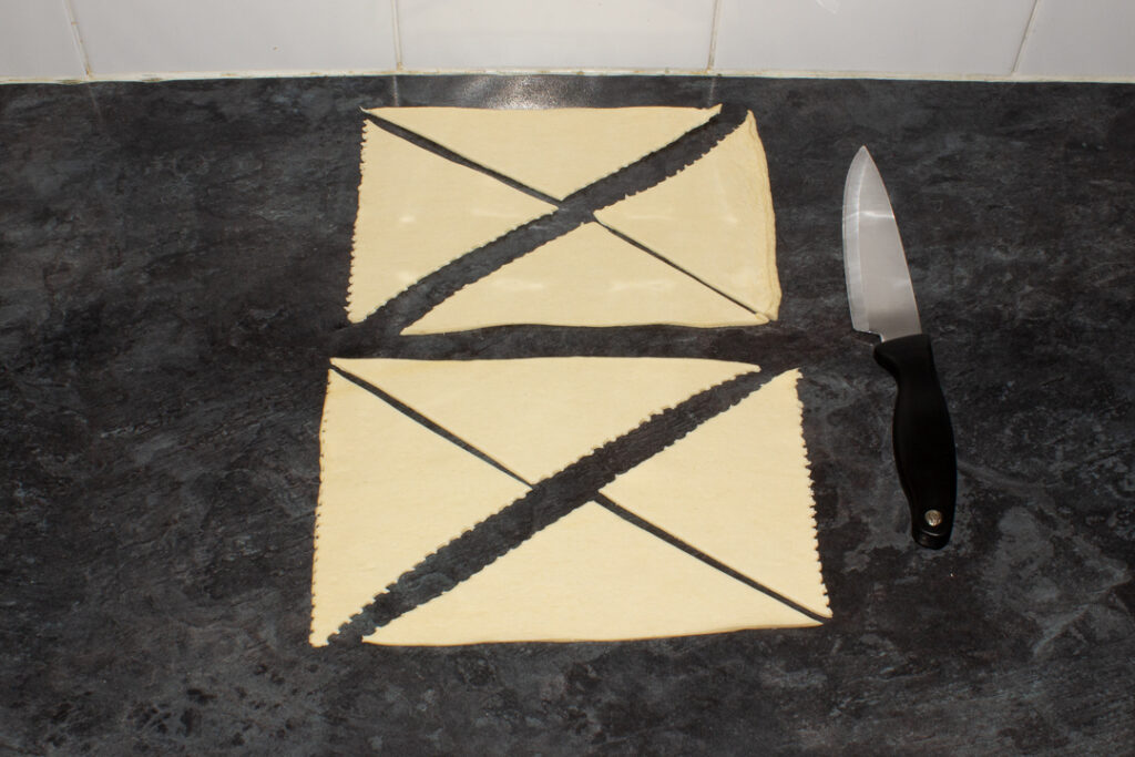 Small triangles of croissant dough on a worktop