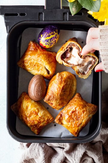 Someone taking an air fried Creme Egg croissant from an air fryer drawer