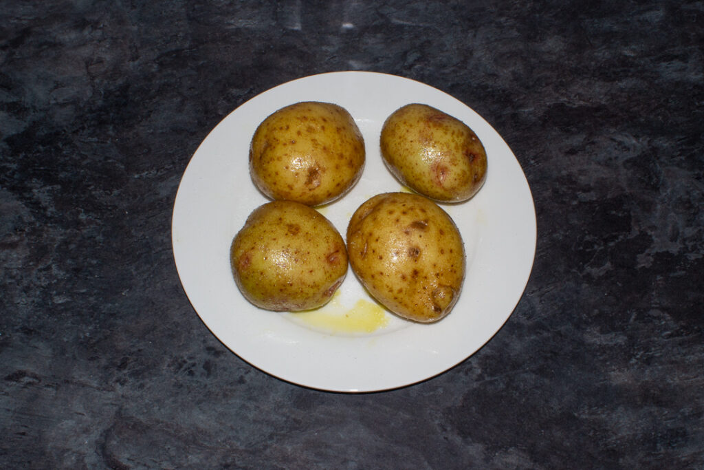 Potatoes covered in oil and salt on a plate