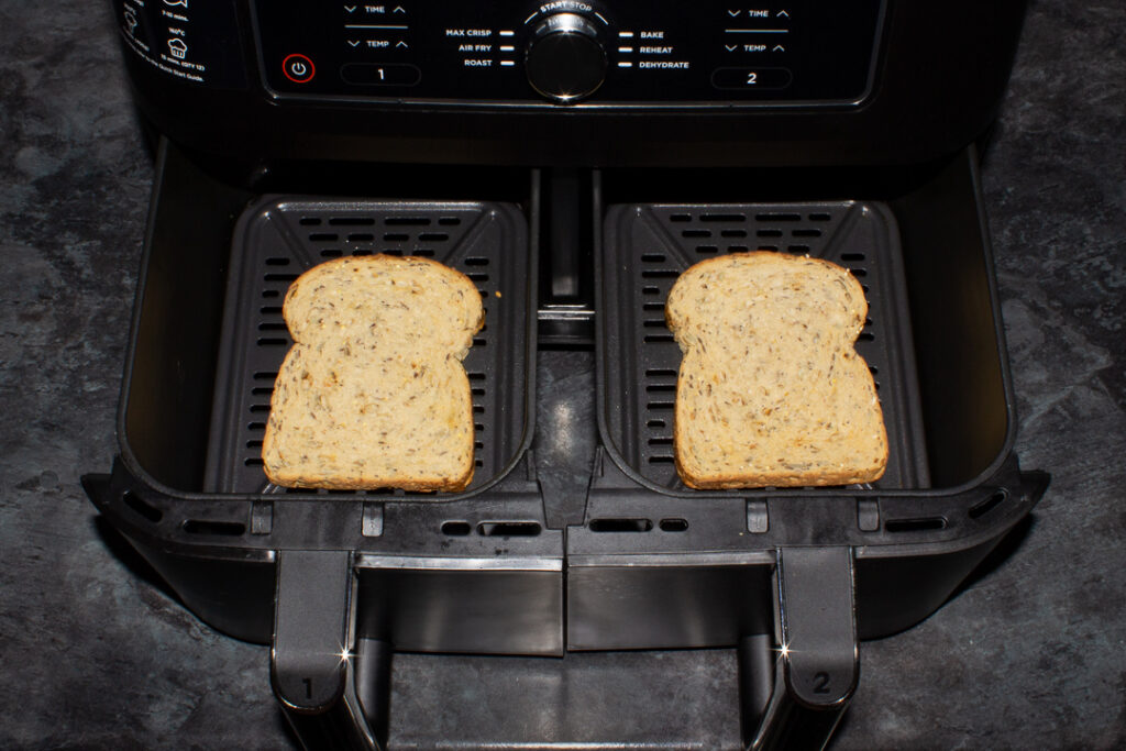 2 partially toasted slices of bread in an air fryer