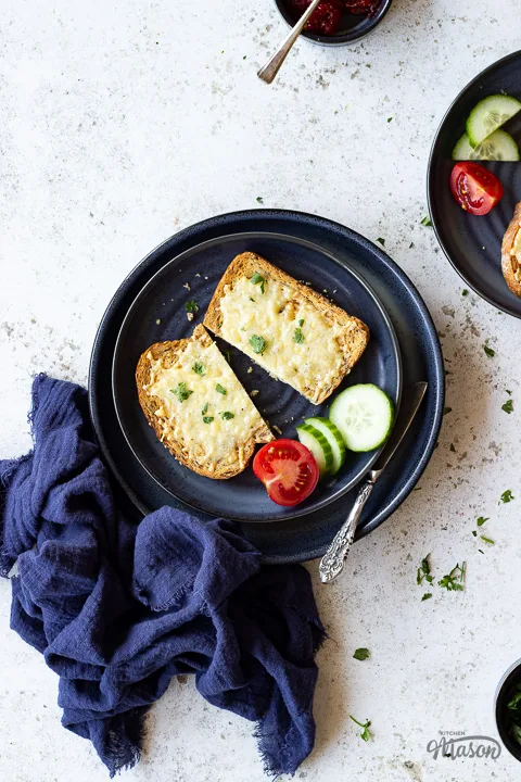 Air fried cheese on toast on a plate with cucumber and tomato