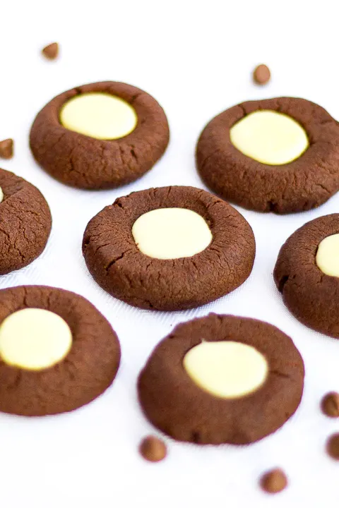 Mint chocolate thumbprint cookies on a worktop with chocolate chips