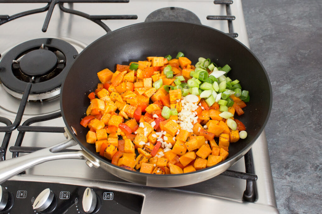 Sweet potato, pepper, spring onion and garlic in a saucepan