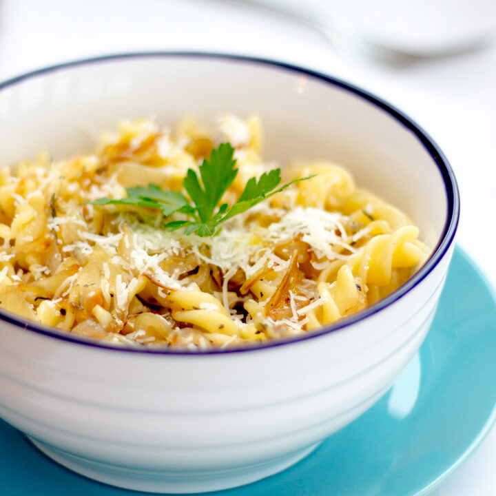 Caramelised onion pasta in a bowl topped with fresh parsley