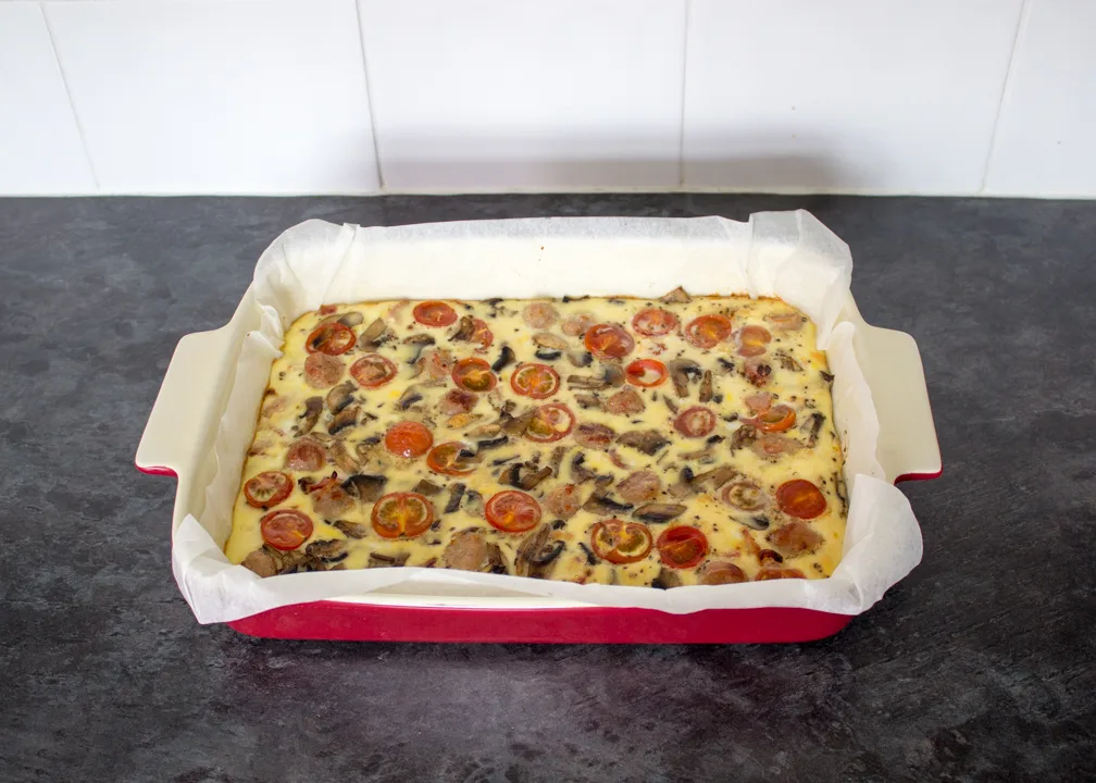A full English baked frittata in a lined ovenproof dish