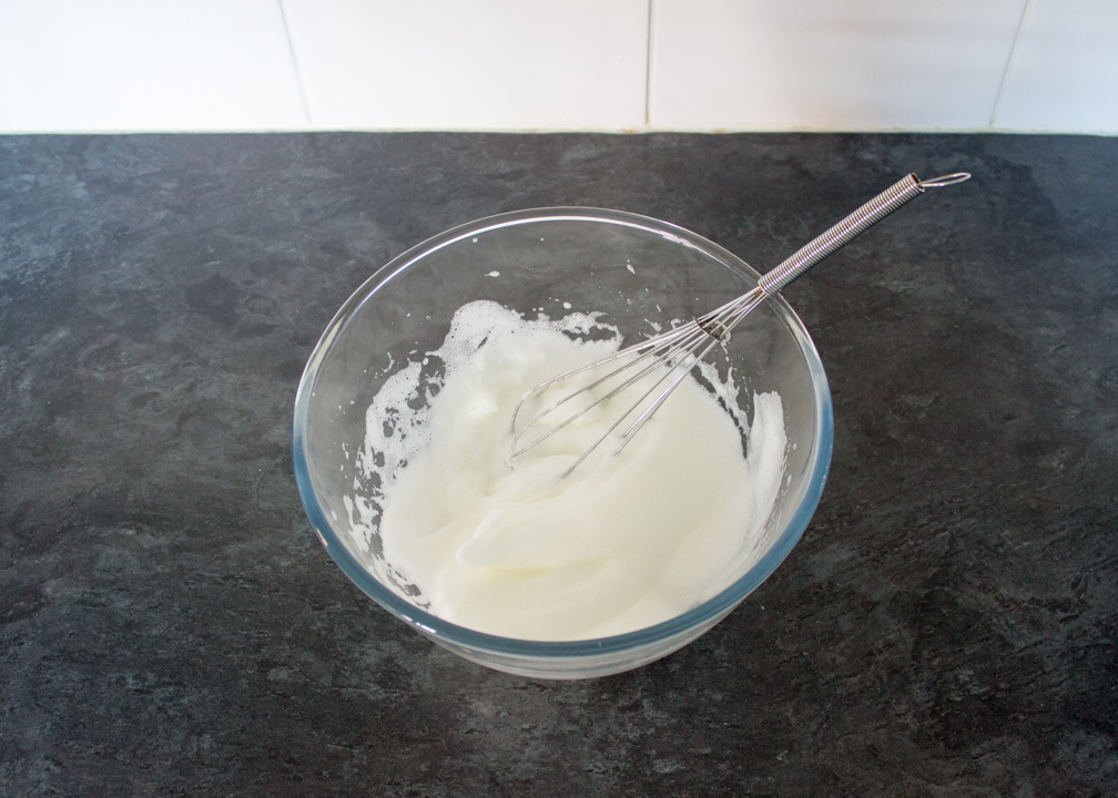 Whipped egg whites in a mixing bowl
