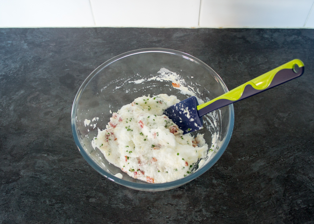 Flavoured egg whites in a mixing bowl with a spatula