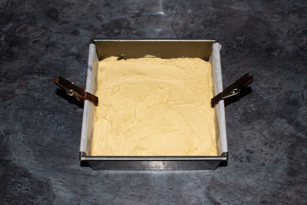 Blondie batter smoothed out in a lined baking tin