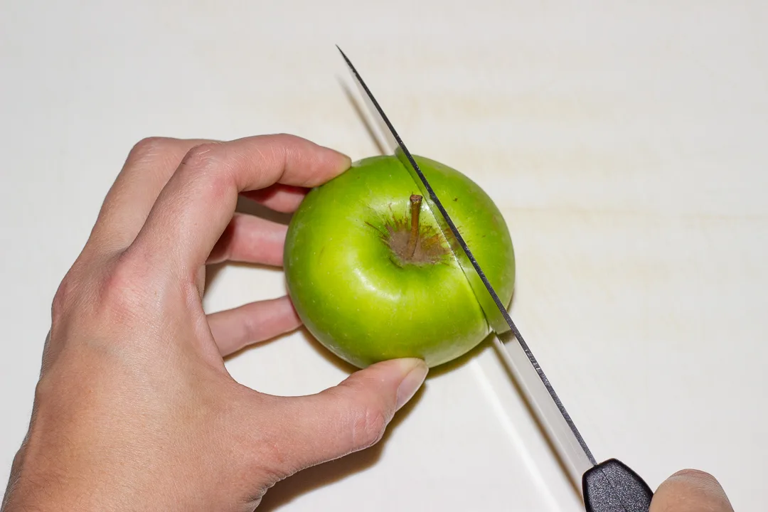 A whole apple being cut