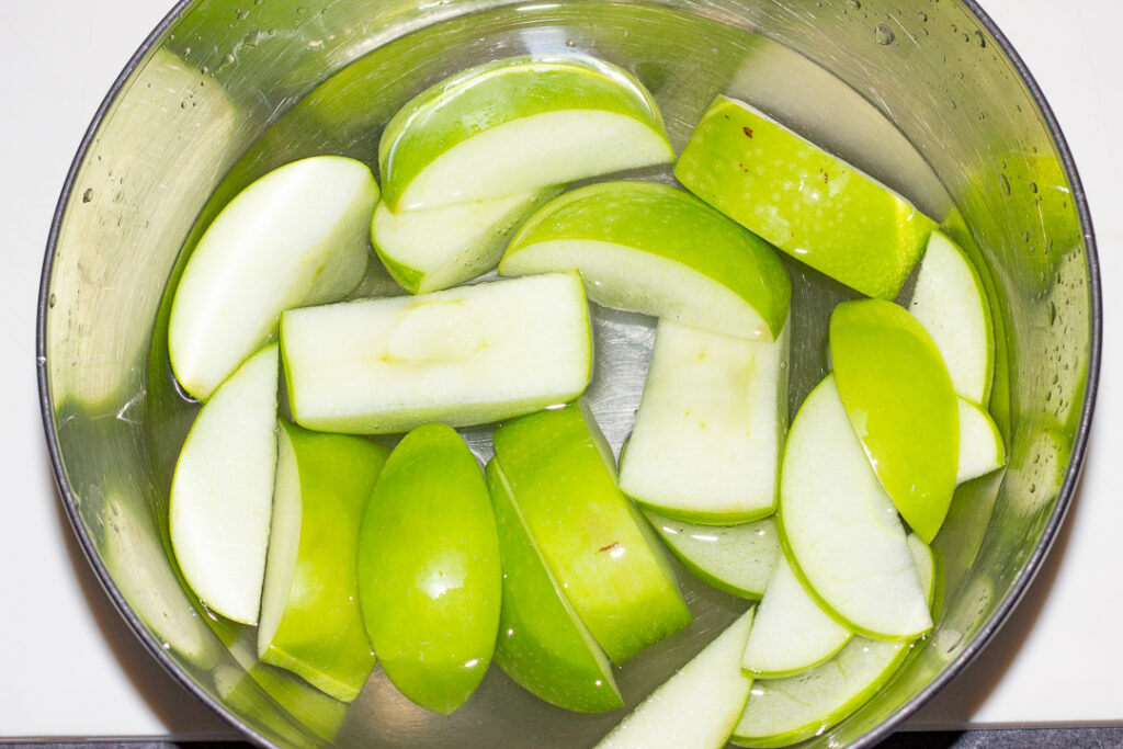 A bowl of sliced apple in salt water solution