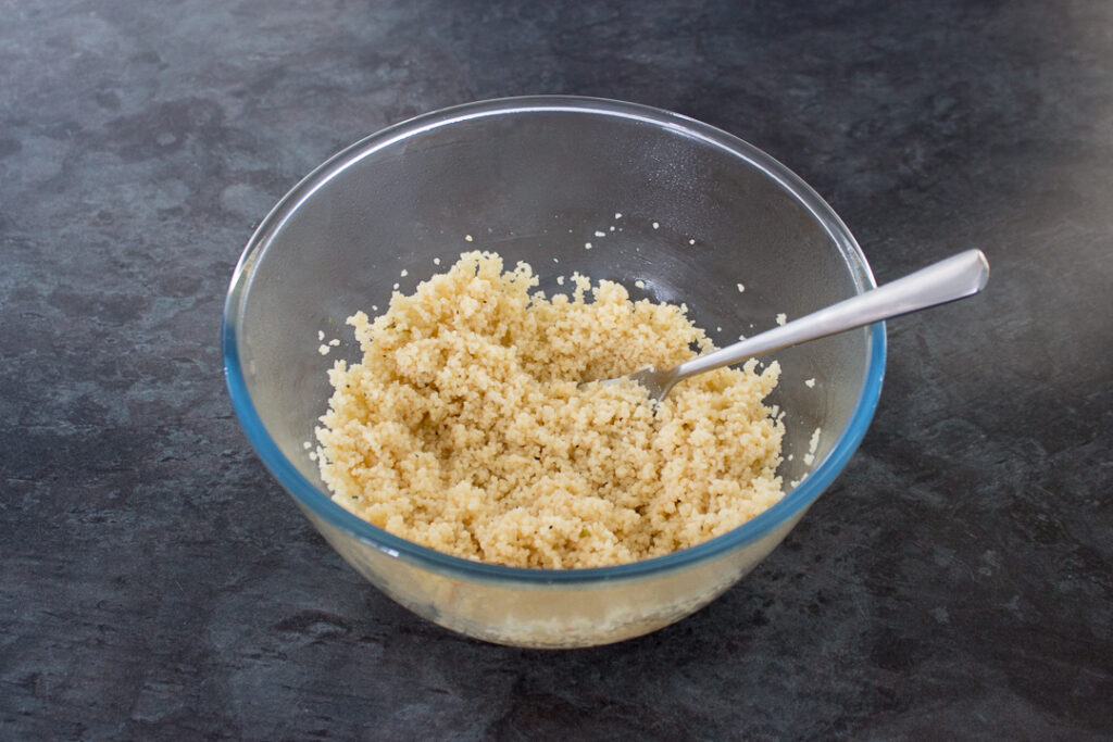 Cooked couscous fluffed up in a bowl