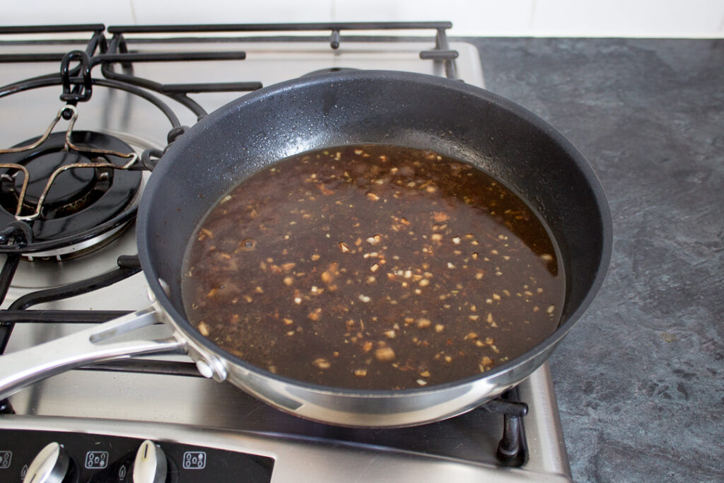 Balsamic chicken sauce being reduced in a pan