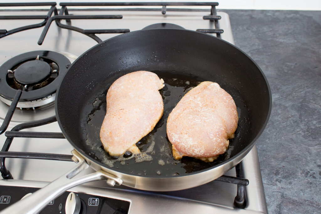 Seasoned chicken in a frying pan