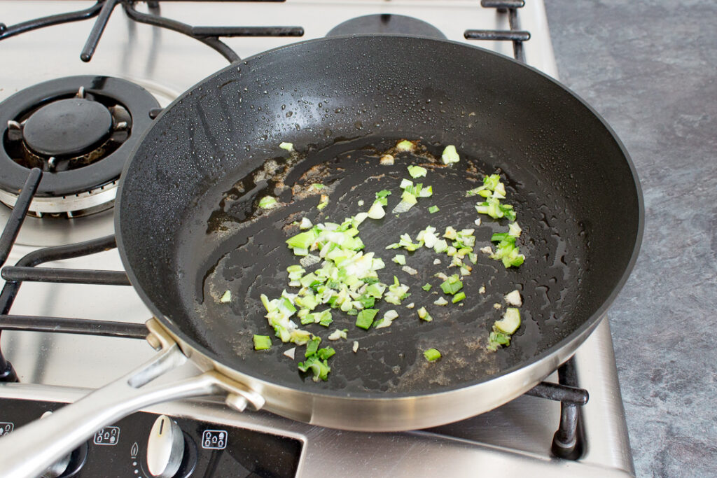 Chopped spring onion in a frying pan
