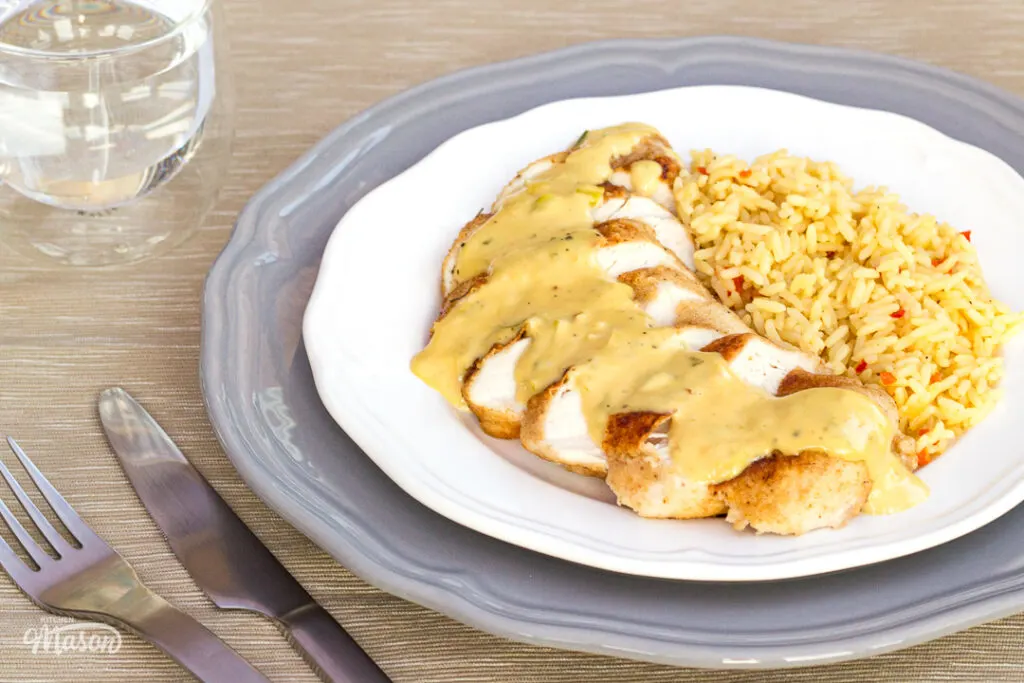 Honey mustard sauce poured over chicken on a serving plate