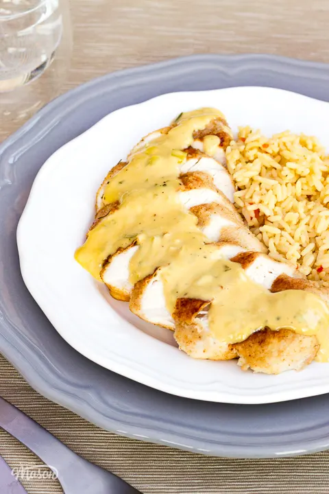Creamy honey mustard chicken on a white plate with rice