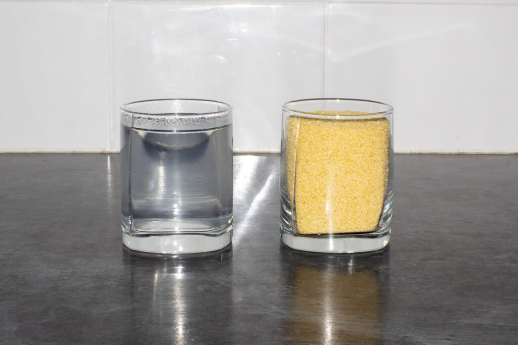 A glass of couscous and a glass of boiling water