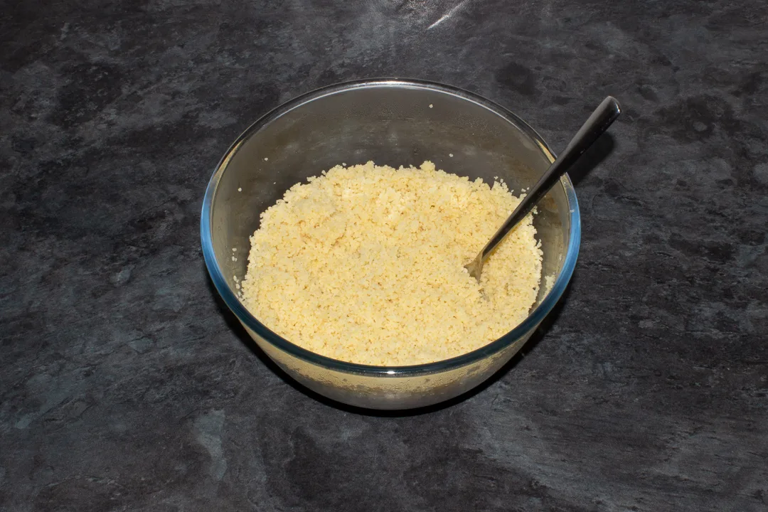 Cooked couscous in a bowl with a fork