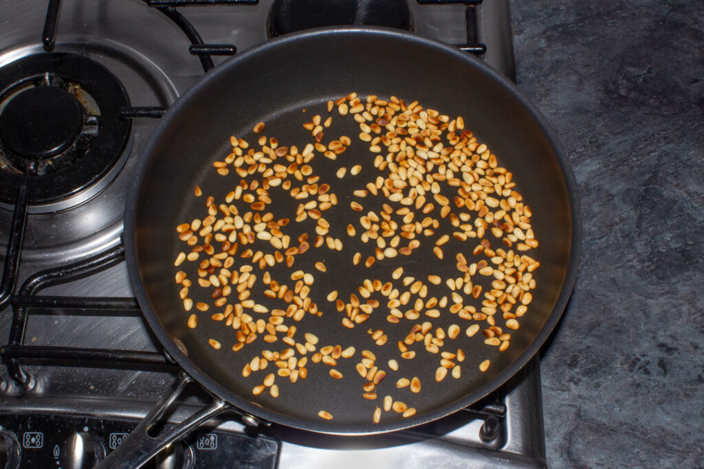 Toasted pine nuts in a frying pan