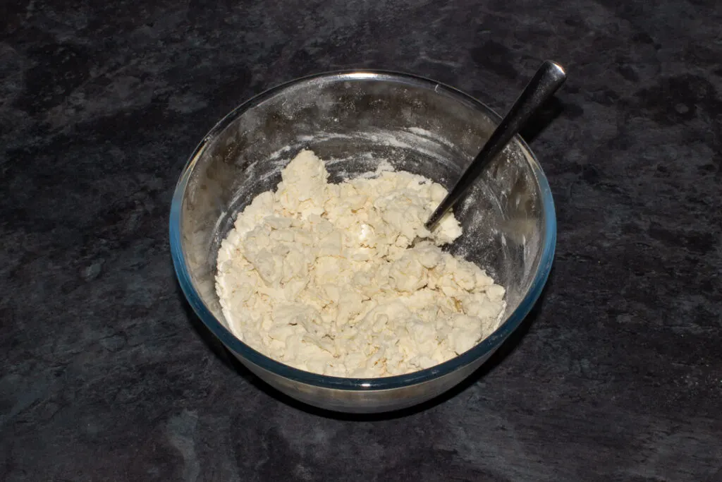 Quick pizza dough in a mixing bowl with a fork