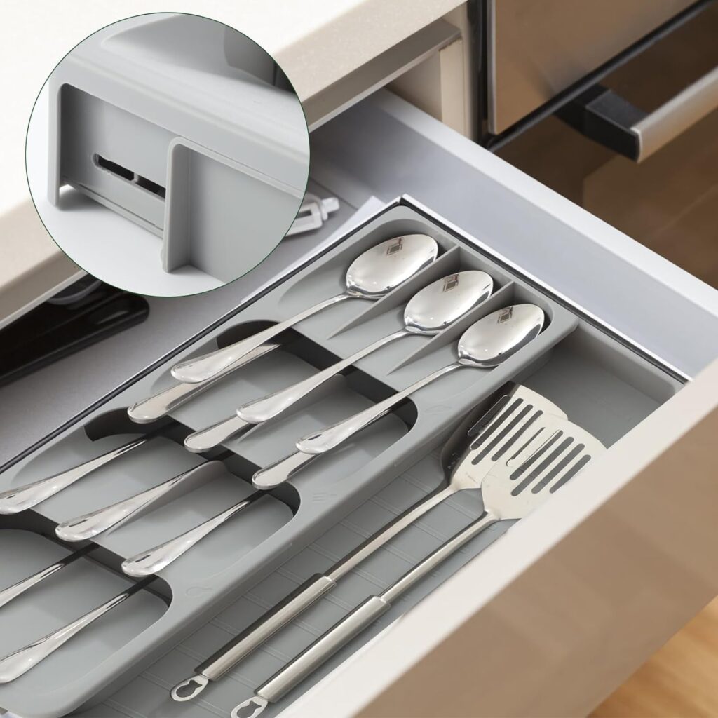 An adjustable cutlery drawer organiser with spoons in it
