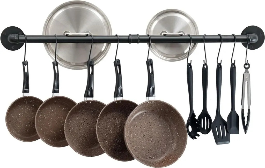 A wall mounted hanger organiser with pans on it
