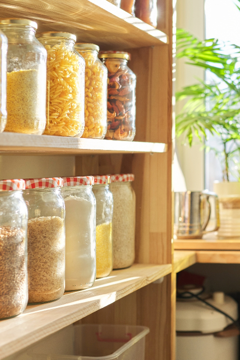 A shelf stocked with jars of dried foods