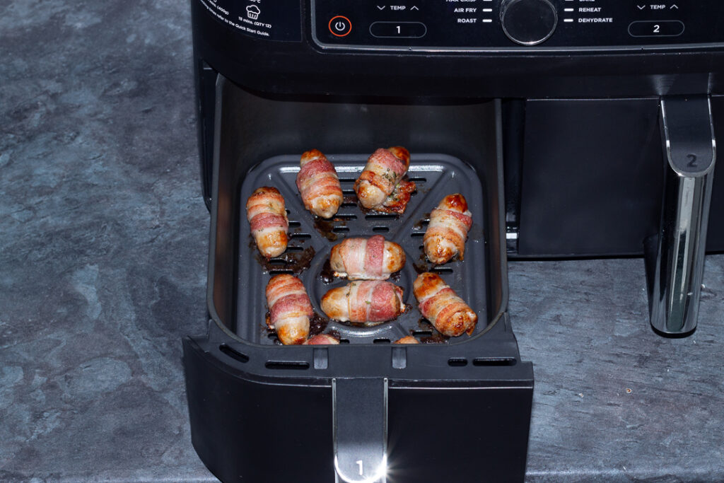 cooked pigs in blankets in an air fryer drawer