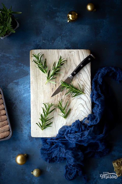 Rosemary being chopped on a board