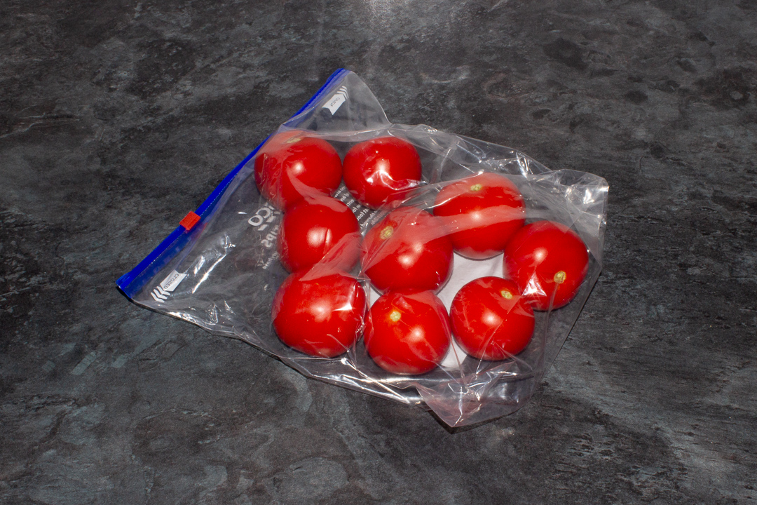 Whole frozen tomatoes in a freezer bag