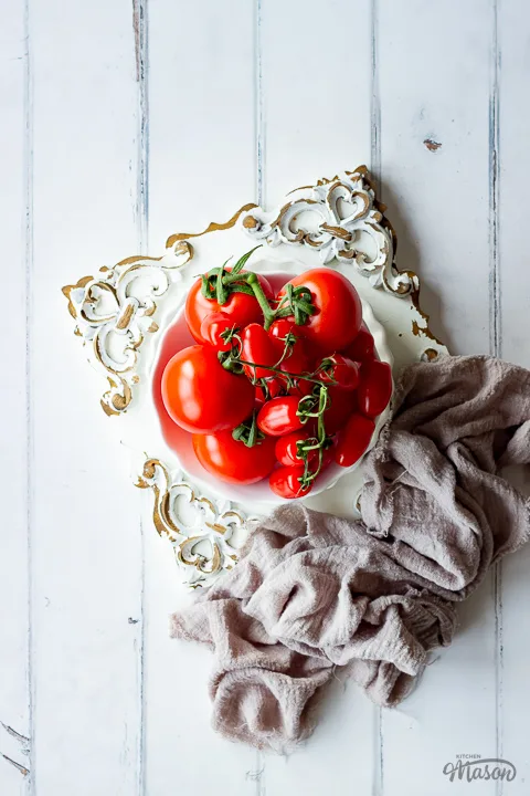 A bowl of tomatoes on an embossed board