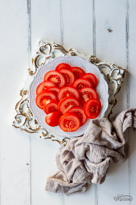 Sliced tomatoes on a plate with a napkin