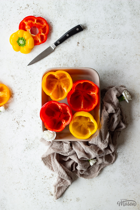 Hollowed out bell peppers in an oven dish
