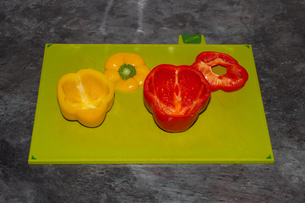 Hollowed out bell peppers on a chopping board