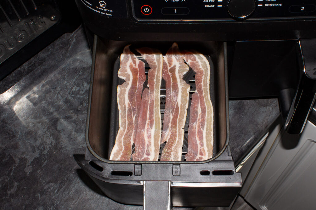 Uncooked streaky bacon in an air fryer