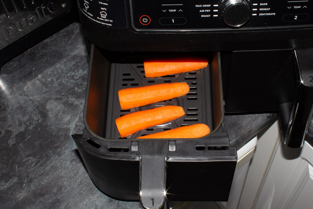 Prepared carrot halves in an air fryer