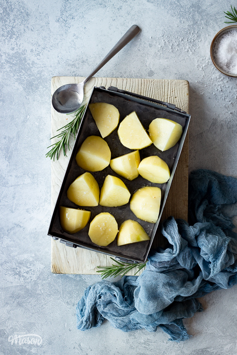 A roasting tray with prepared potatoes