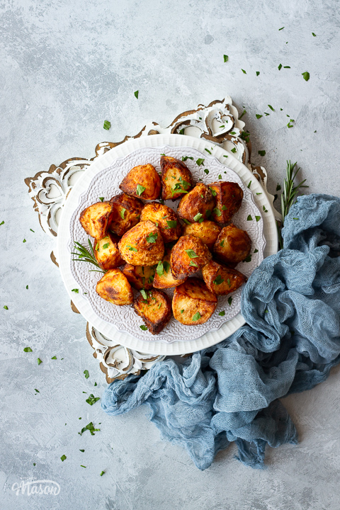 A plate of air fryer roast potatoes scattered with parsley