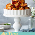 A pyramid of air fryer roast potatoes in a dish on a stand. A text overlay says' Air Fryer Roast Potatoes'.