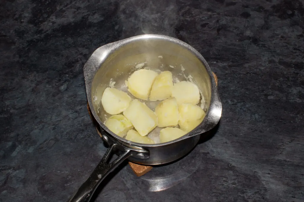 par boiled potatoes fluffed up in a pan