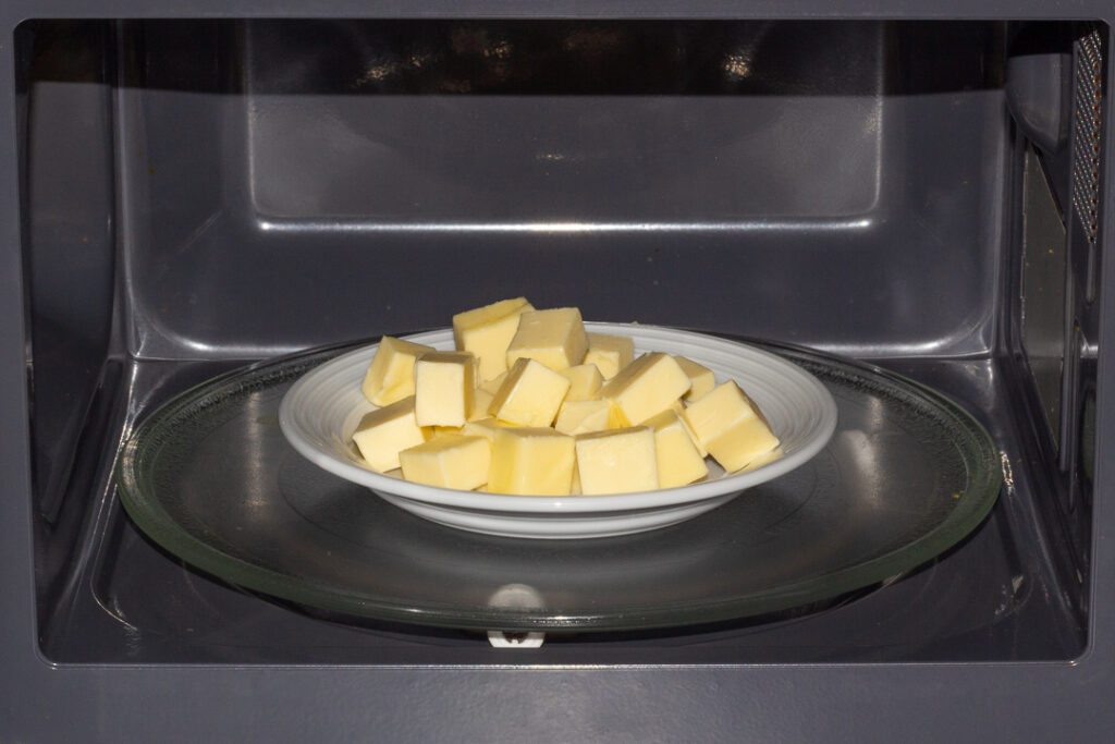A plate of cubed butter in a microwave