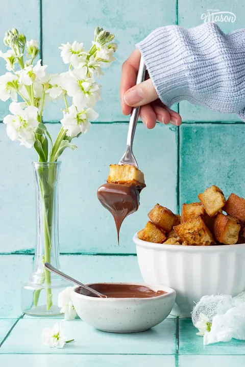Air fryer crumpet churros being dunked into Nutella