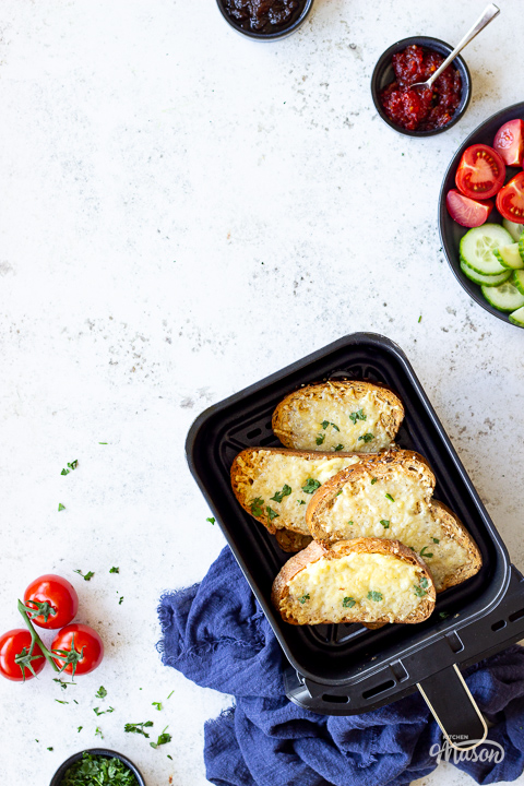 Cheese on toast in an air fryer drawer with salad on the side