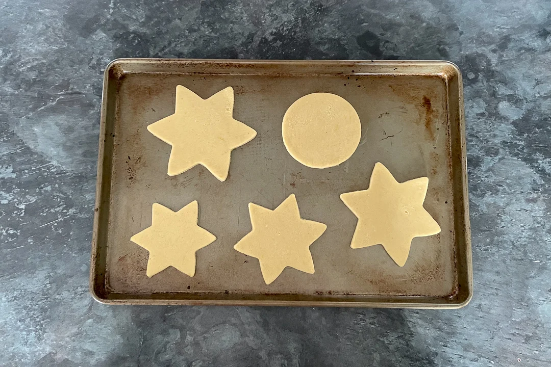 Unbaked cookie shapes on a large baking tray