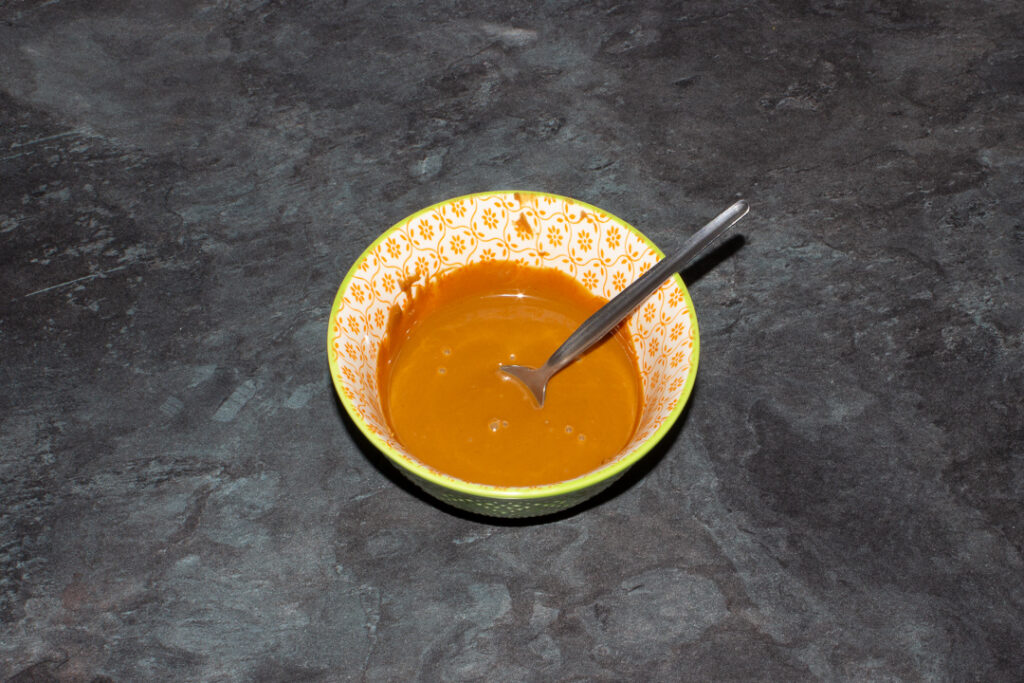 Melted Biscoff spread in a bowl with a spoon