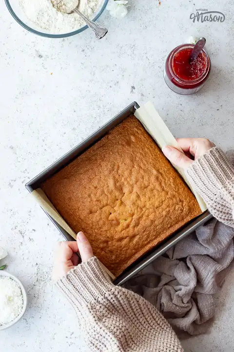 Someone lifting cake out of a tin.
