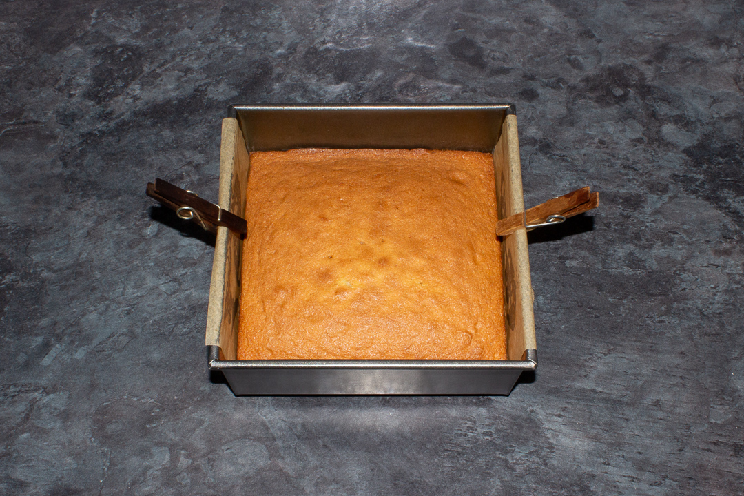 Baked sponge cake in a lined square tin