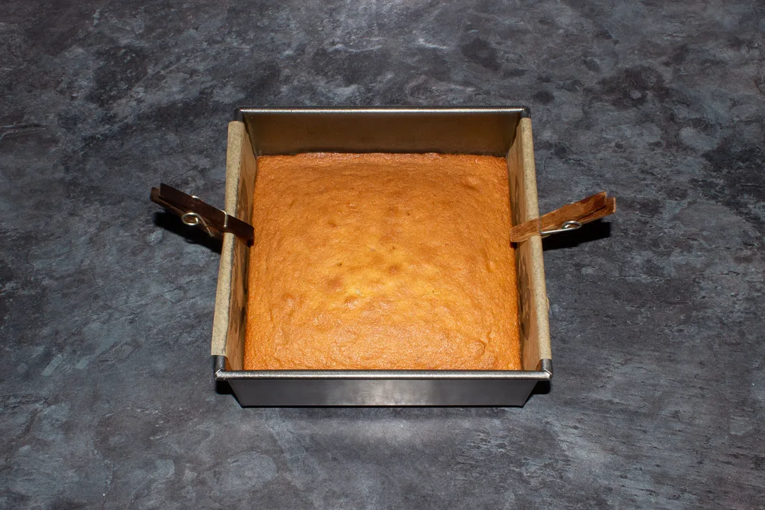 Baked sponge cake in a lined square tin